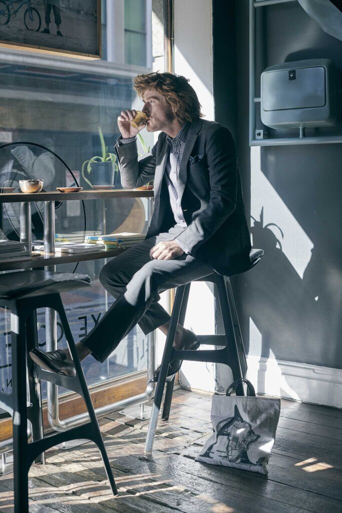 Ein Mann Café trinkend gekleidet in einem lockeren Anzug von Lewin