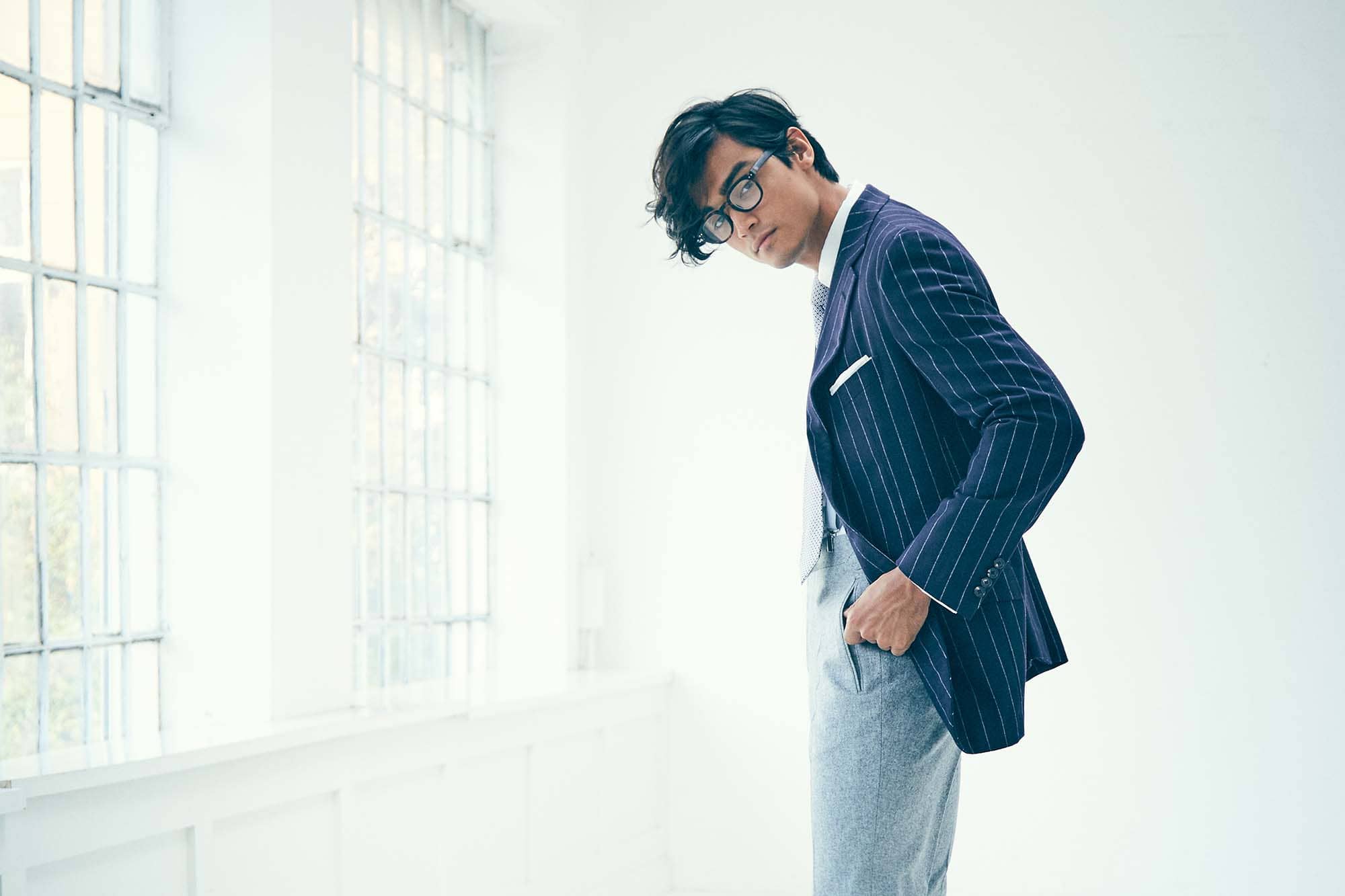 Ein Mann im gestreiften Jacket steht seitlich.