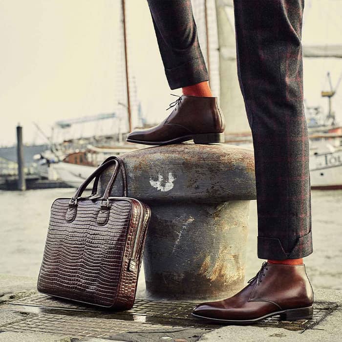 Ein Mann steht mit roten Schuhen am Hafen Hamburg