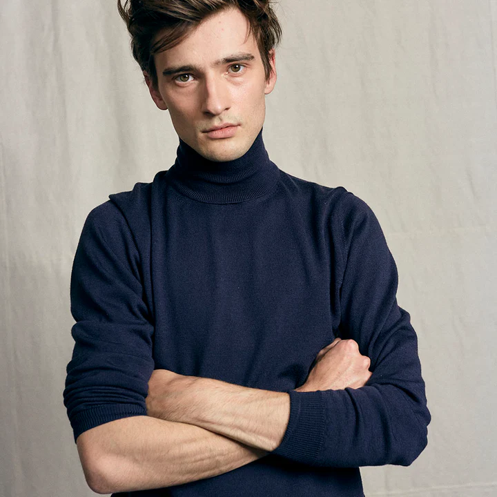 Ein Mann in einem blauen Rollkragenpullover