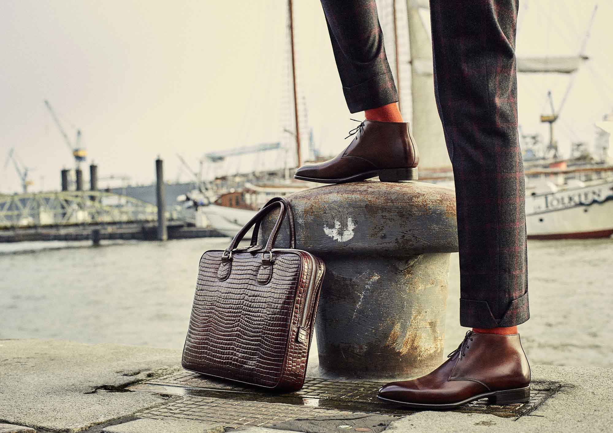 Ein Mann steht mit roten Schuhen am Hafen Hamburg