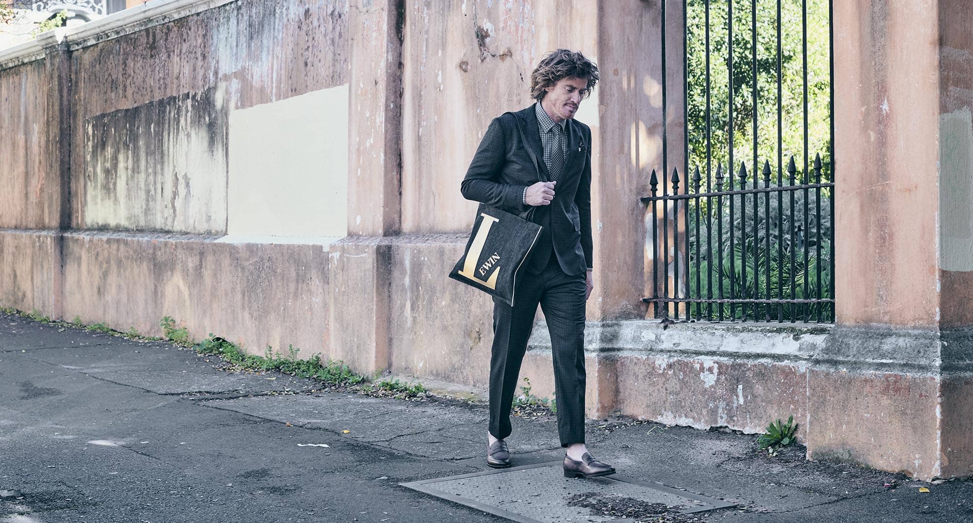 Ein Mann geht an einer Mauer in einem Anzug von Lewin